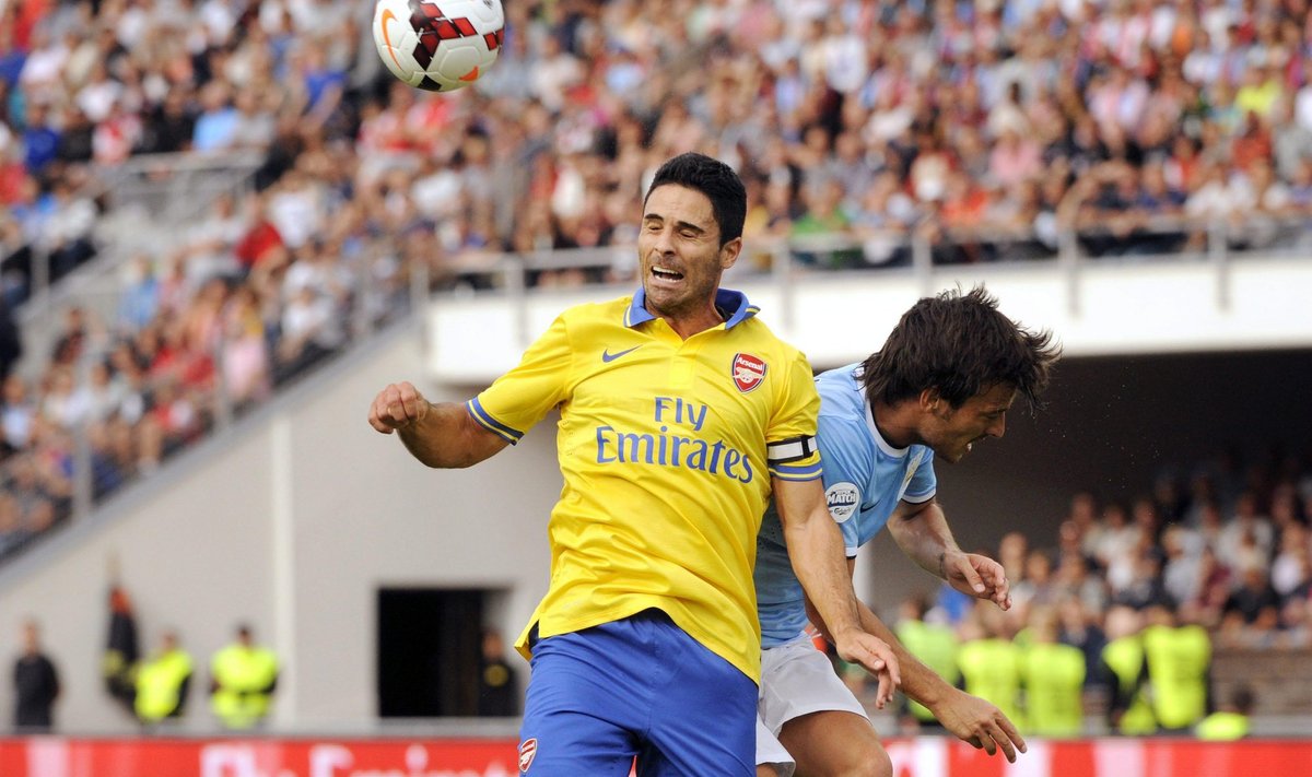Arsenal's Arteta heads the ball before Manchester City's Silva during their friendly match in Helsinki