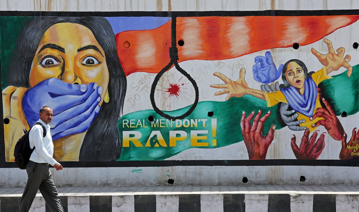 POOGE NAD ÜLES: Mees möödumas ühele Jammu majaseinale joonistatud vägistamisvastasest grafitist.