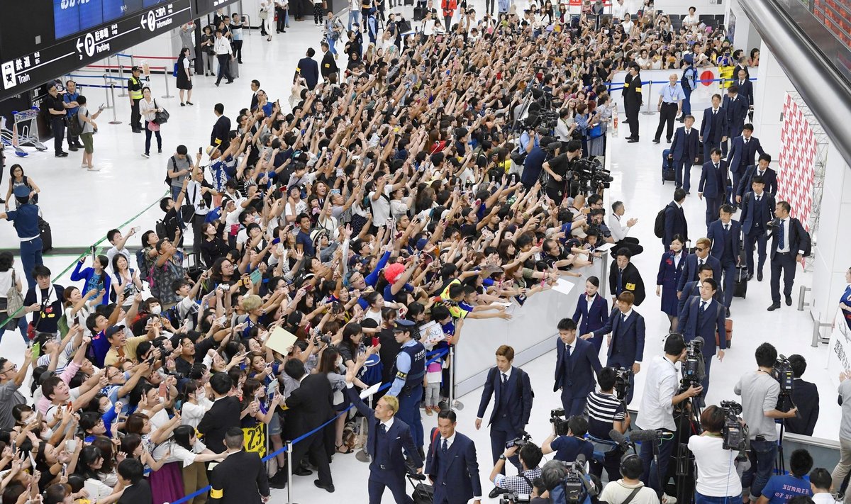 Members of the Japanese national football team are greeted by fans as they return to Narita international airport in  Narita