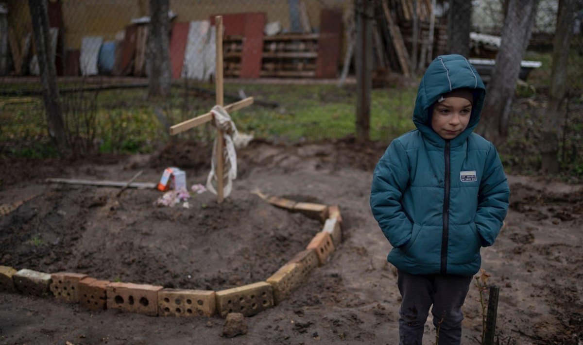 Kuueaastane poiss Kiievi oblastis oma koduhoovi maetud ema haual. 