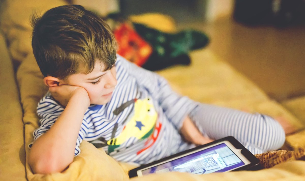 Little,School,Kid,Boy,Making,Homework,With,Tablet.,Schoolchild,Reading