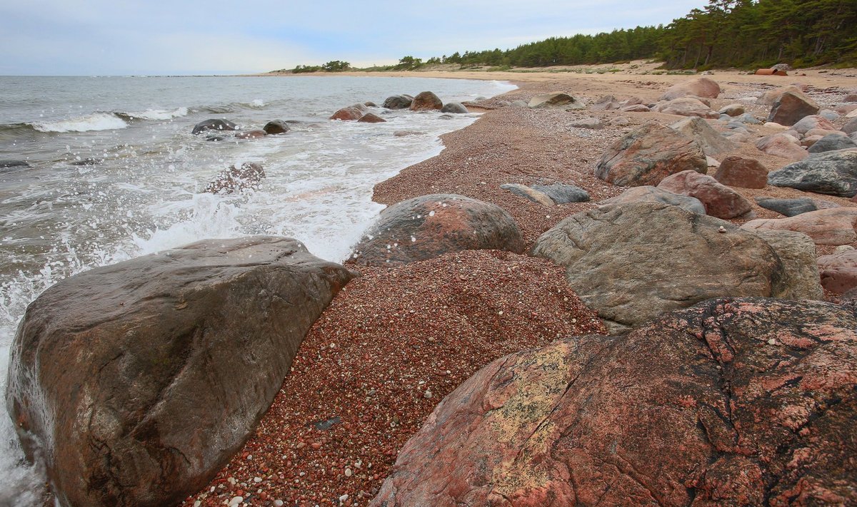 Kivid ja liiv loovad rauget meeleolu läände kaarduvas Ristna rannas.