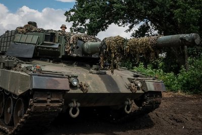 Украинский военнослужащий управляет танком Leopard 2A4 во время тест-драйва в мастерской в ​​неизвестном месте на востоке Украины.