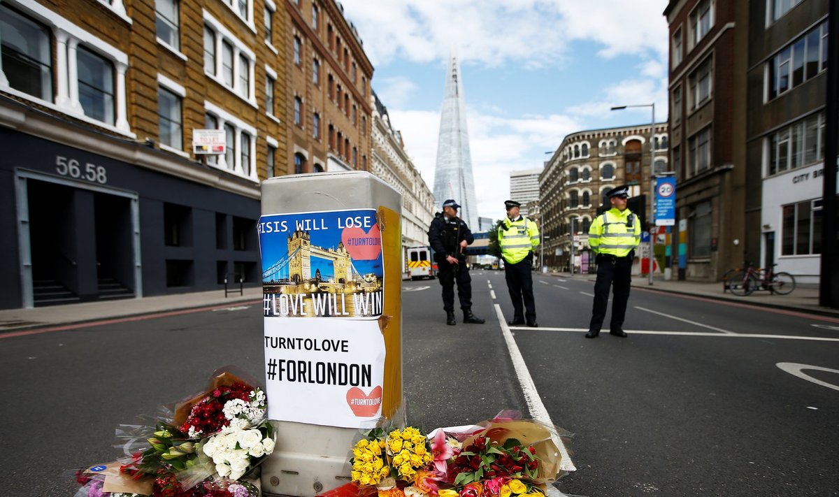 Flowers and messages lie behind police cordon tape near Borough Market after an attack left 7 people dead and dozens injured in London