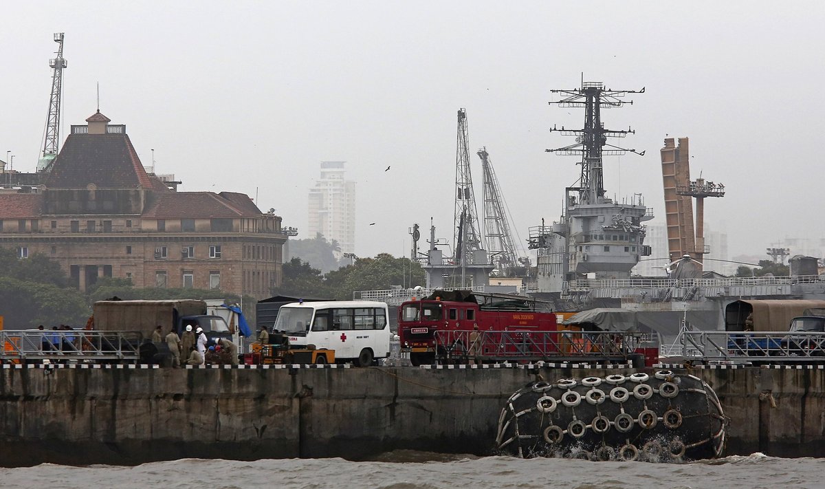 Indian Navy personnel and rescue workers stand on a dock at the naval dockyard in Mumbai