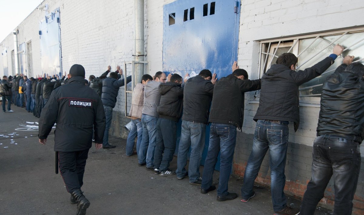 Russian police detain migrant workers during a raid at a vegetable warehouse complex in the Biryulyovo district of Moscow