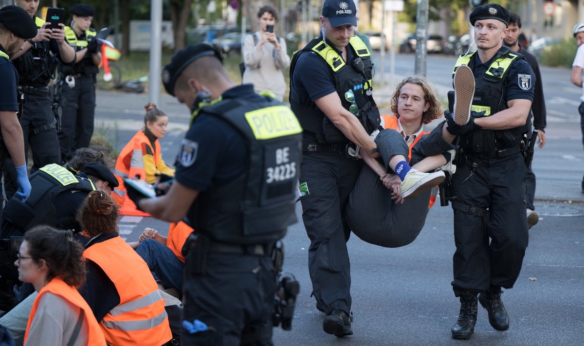 Politseinikud kannavad minema Berliini tänavat blokeerinud aktivisti.