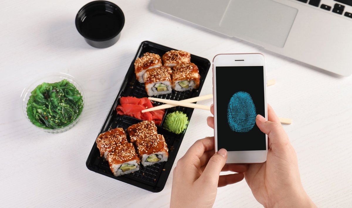 Woman,Holding,Mobile,Phone,With,Fingerprint,Sensor,At,Table,,Closeup