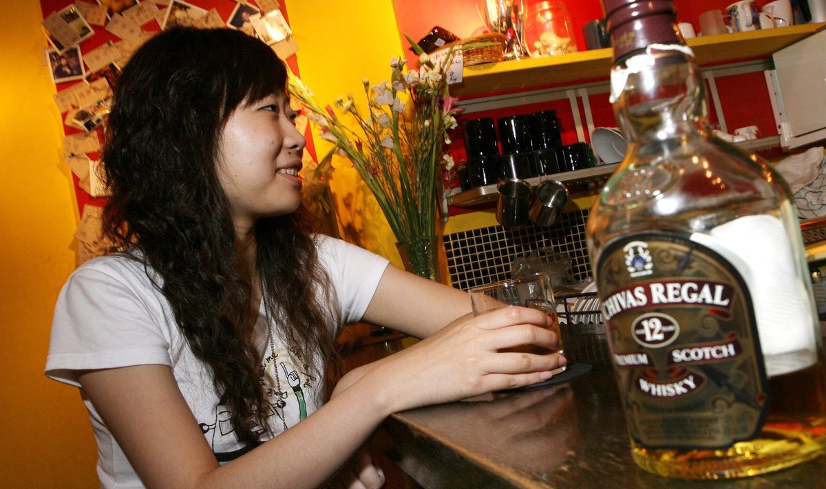 Noor Hiina naine Shanghai baaris Chivas Regali klaasiga.