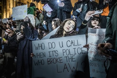 Meeleavaldaja sõnumiga: „Keda sa kutsud, kui just politsei rikub seadust?“ Thbilisi parlamendihoone ees.