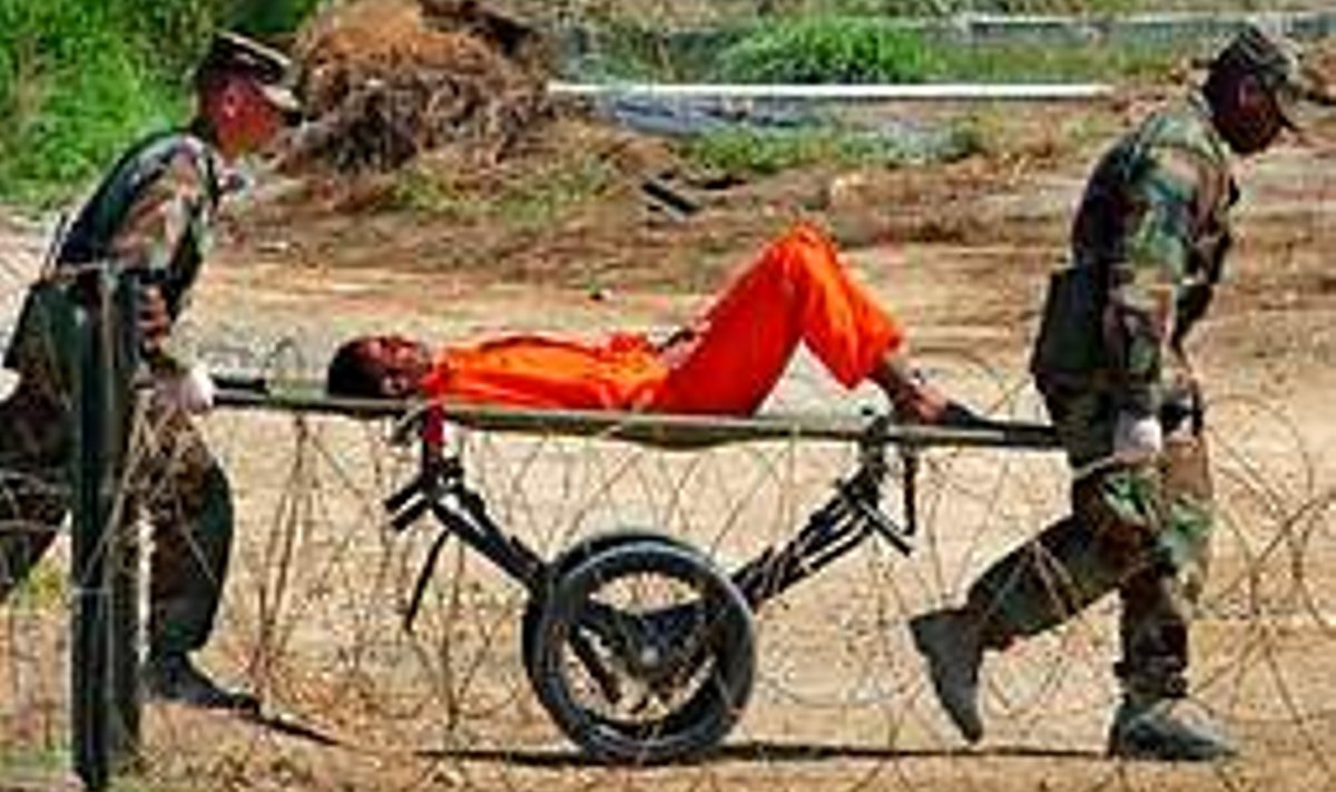 Teekond Ülekuulamisele: Pilt on tehtud 2002. aasta  2. veebruaril Guantanamo laagris. Ametliku legendi kohaselt on tegemist mehega, kes sai lahingutegevuses haavata. Pangem tähele, et haavatu on käe- ja jalaraudades. Scanpix