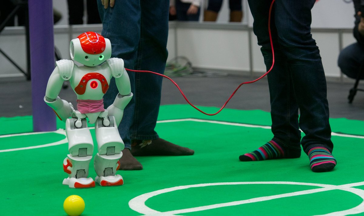 Robotid on jalgpalliplatsil, palli kontrollib veel inimene.