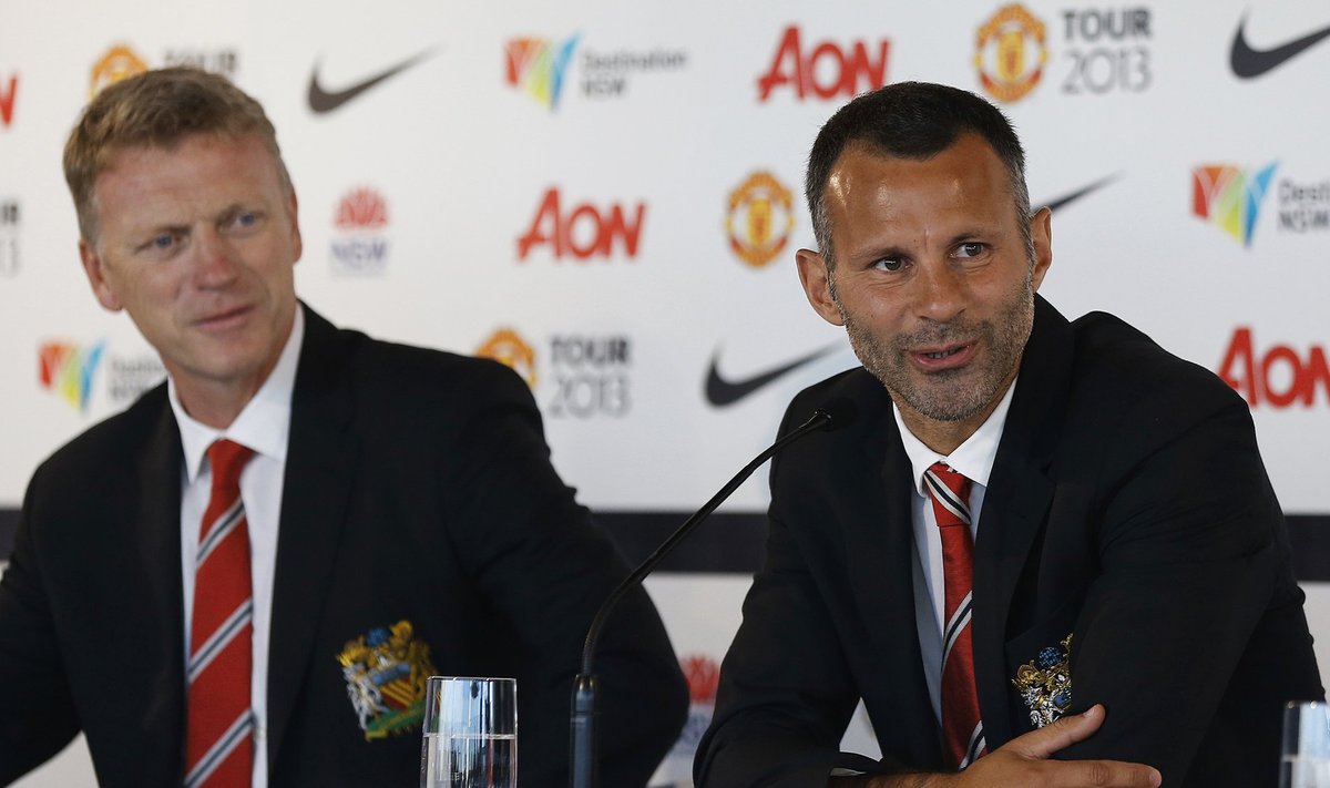 File photo of Manchester United player Giggs talking while manager Moyes looks at him during a news conference in central Sydney