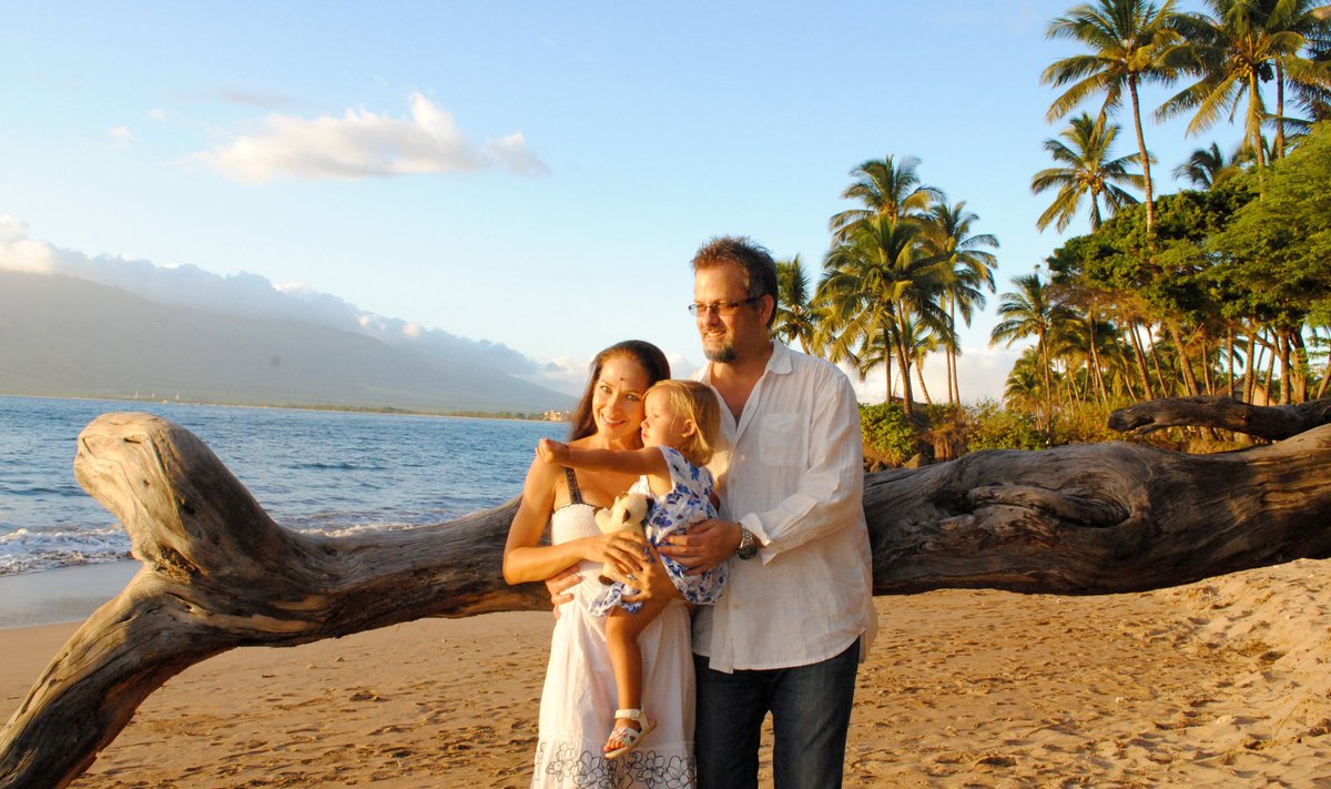 Kristel koos elukaaslase Bradi ja tütre Trin-Elliga kodurannas päikeseloojangu ootel.