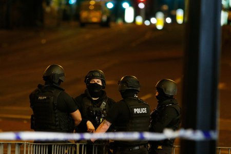 Armed police officers stand near the Manchester Arena, where U.S. singer Ariana Grande had been performing, in Manchester, northern England, Britain