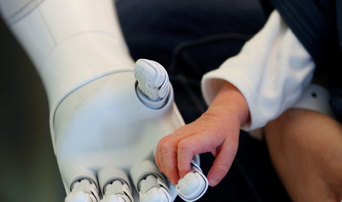 Robot Pepper Belgias AZ Damiaani haiglas vastsündinu kätt hoidmas.