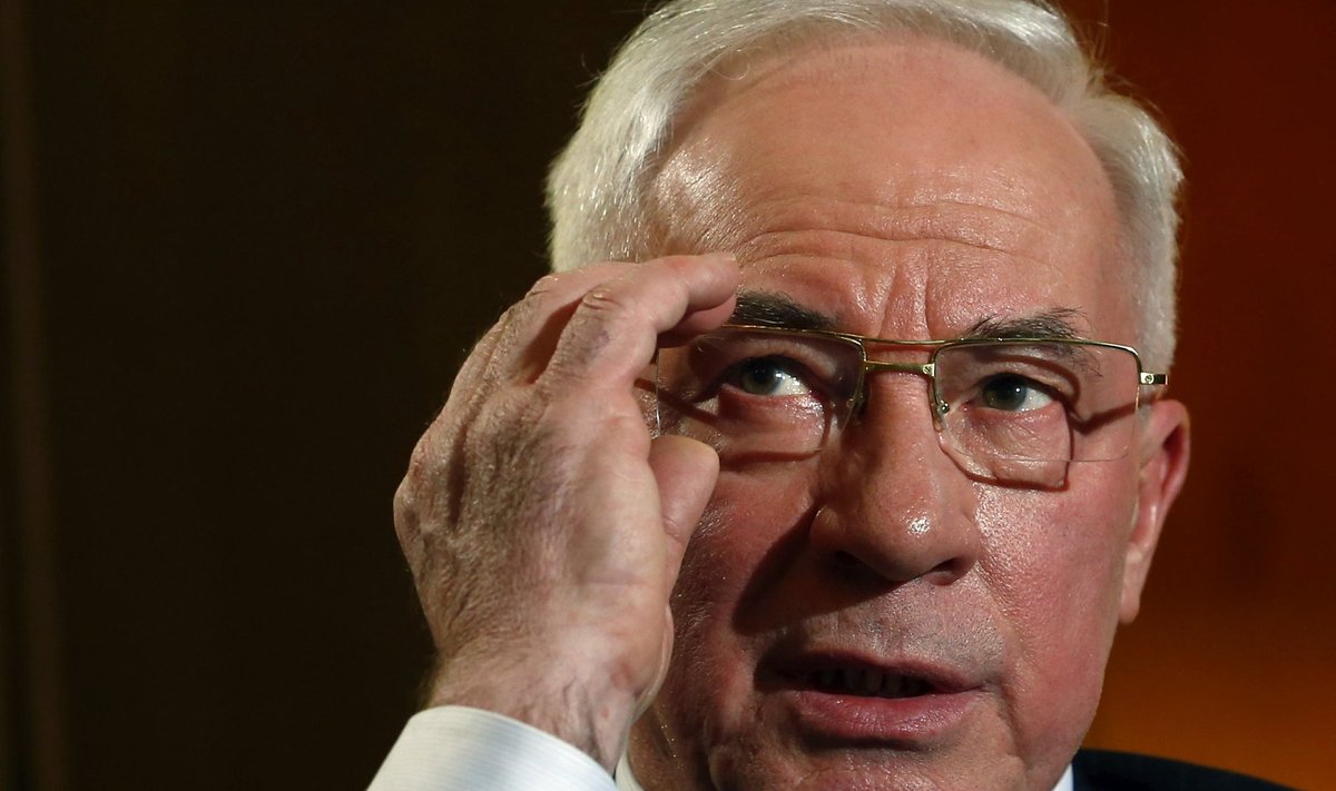 Ukrainian Prime Minister Azarov adjusts his glasses during an interview at World Economic Forum in Davos