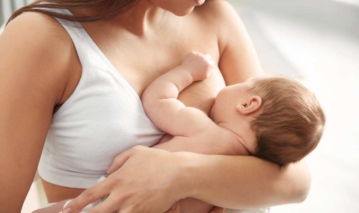 Young,Woman,Breastfeeding,Her,Baby,On,Blurred,Background,,Closeup