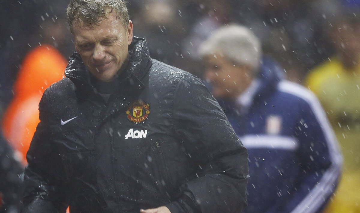 Manchester United's manager Moyes leaves the pitch after referee Clattenburg suspended play temporarily due to bad weather during their English League Cup quarter-final soccer match against Stoke City at the Britannia stadium
