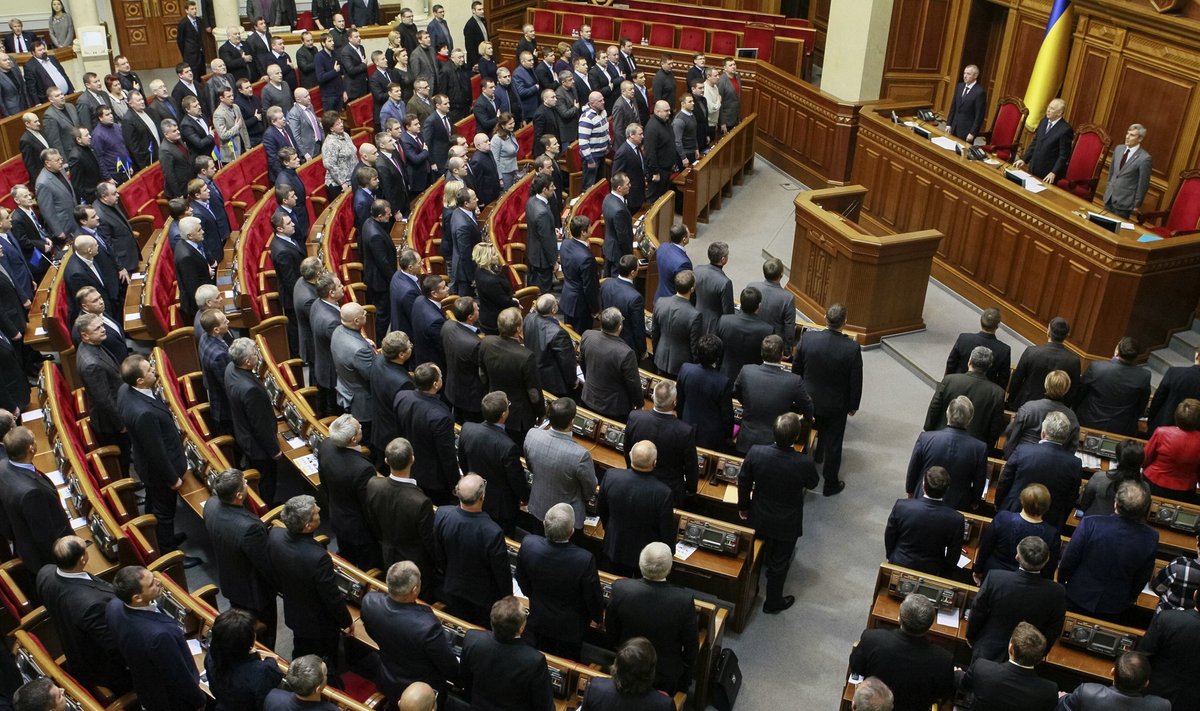 Ukrainian officials observe a minute of silence in memory of victims of last week's unrest during a session in Parliament in Kiev