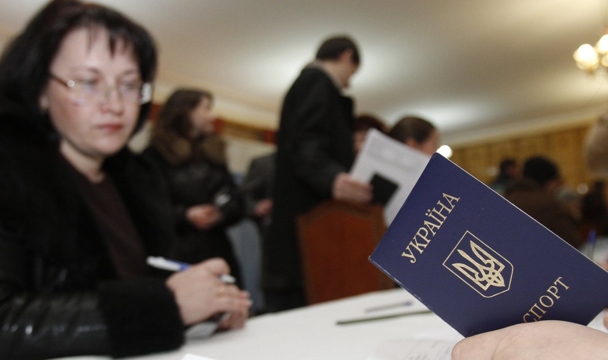 An assistant holds a passport of a Ukrainian resident preparing to vote at the Ukrainian embassy to Russia in Moscow