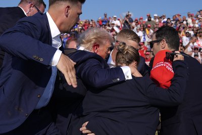 Trump eskorditakse lavalt ära, turvatöötajad tõstavad taas käed, et kaitsta tema pead.