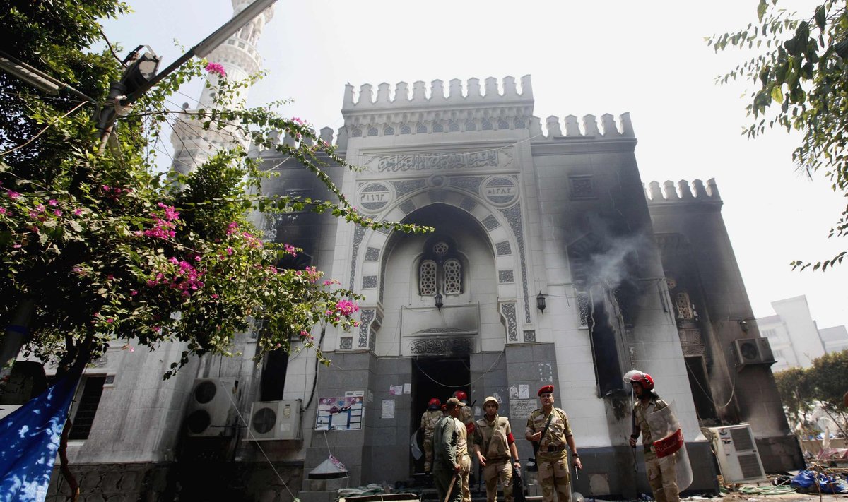 Members of the military police stand outside the burnt Rabaa Adawiya mosque, the morning after a protest camp was cleared nearby, in Cairo