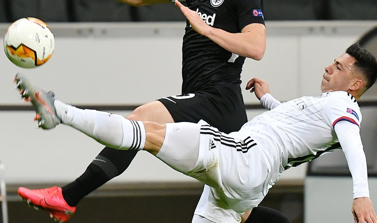 Филип Костич из Франкфурта соперничает с Бласом Риверосом из Базеля во время первого матча 1/8 финала Лиги чемпионов УЕФА 