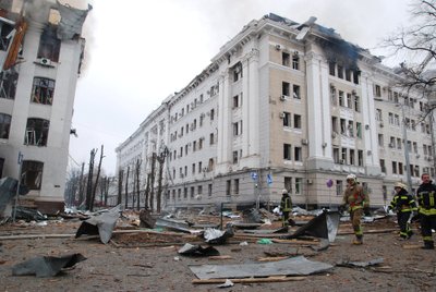 Firefighters work near damaged buildings of the Kharkiv National University and a regional police department in Kharkiv