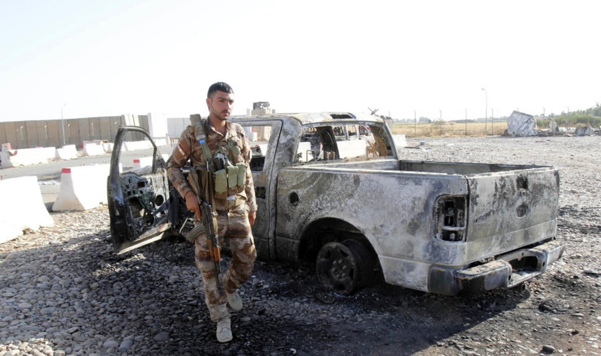 Kurdi võitleja Iraagi relvajõududele kuulunud sõiduki vraki juures Kirkuki linna veerel