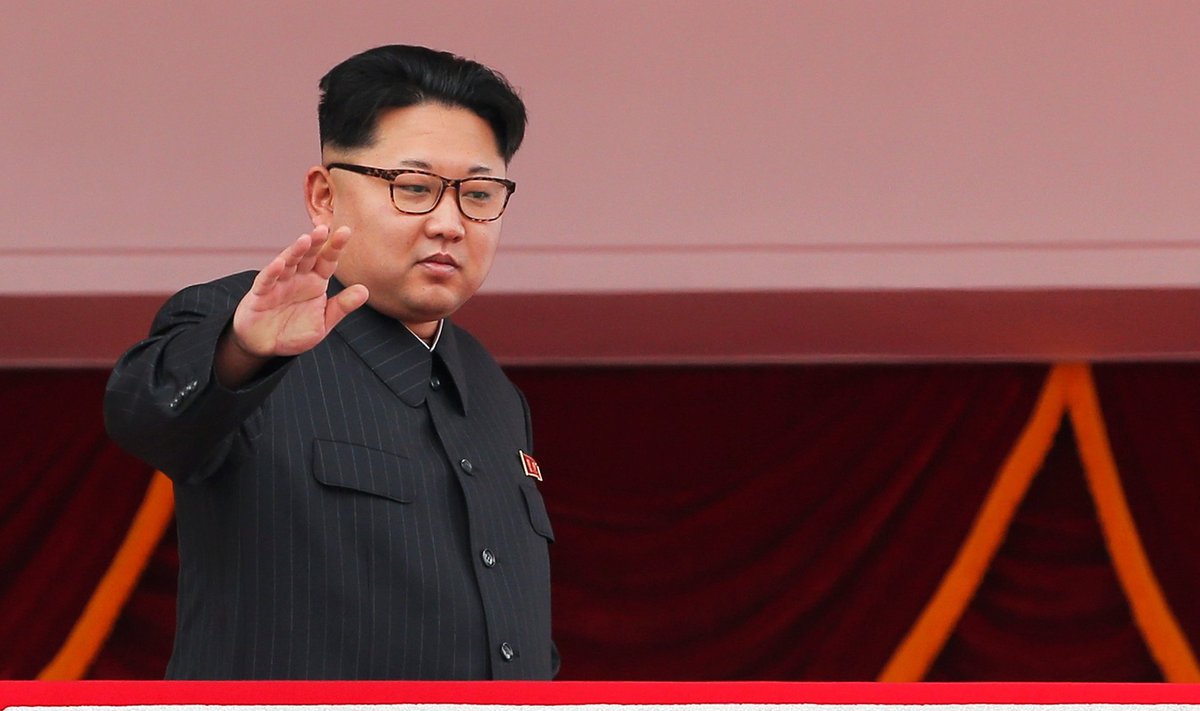 North Korean leader Kim Jong Un waves as he presides over a mass rally and parade in Pyongyang