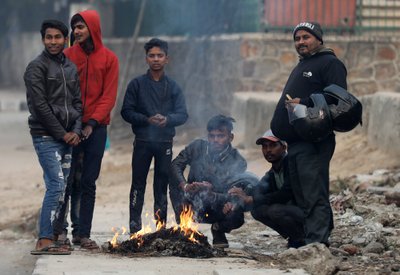 KÜLM ON: Delhi kodanikud end tule juures soojendamas.