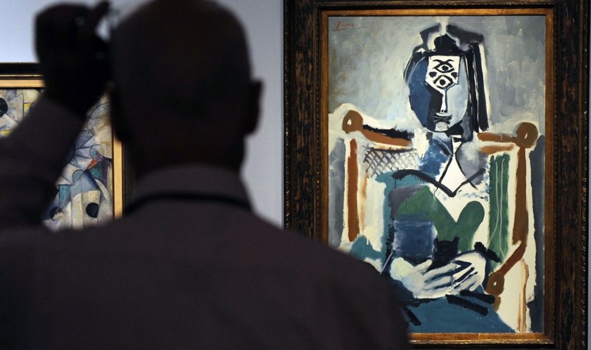 A Russian man looks at a painting by Pablo Picasso on display in Moscow on May 19, 2010 before its planned auction at Sotheby's.  AFP PHOTO / NATALIA KOLESNIKOVA