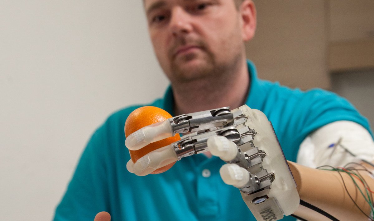 Viie aasta tagune pilt Dennis Aabo Sörensenist hoidmas robotkäe sõrmede vahel apelsini.  