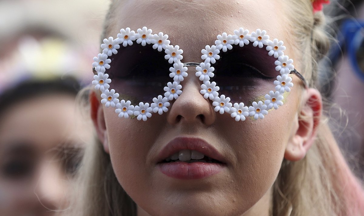 A festival goer watches the English National Ballet perform on the Pyramid stage at Worthy Farm in Somerset, during the Glastonbury Festival