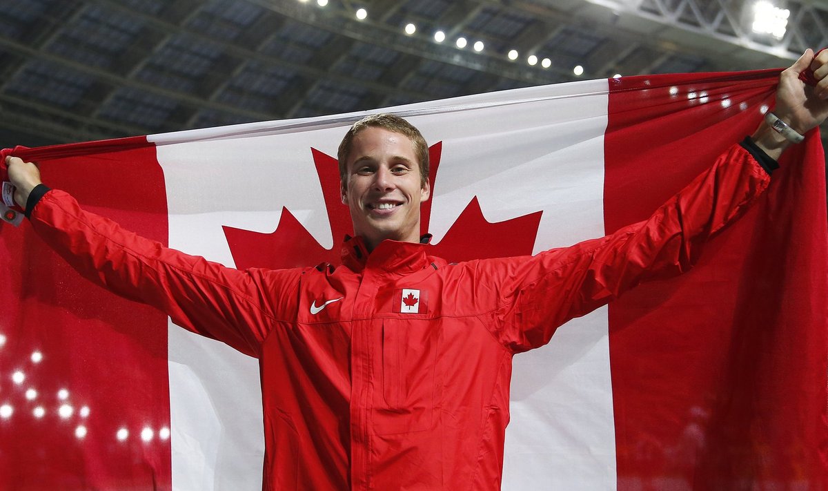 Drouin of Canada holds up his national flag as he celebrates winning bronze medal in the men's high jump final during the IAAF World Athletics Championships at the Luzhniki stadium in Moscow