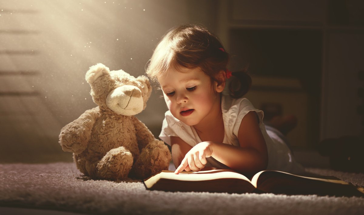 Child,Little,Girl,Reading,A,Magic,Book,In,The,Dark
