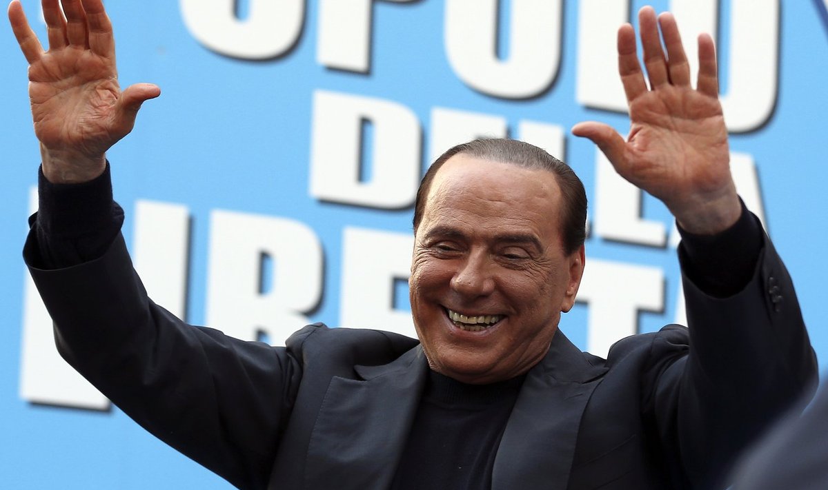 Former Italian Prime Minister Silvio Berlusconi waves during a rally to protest his tax fraud conviction, outside his palace in central Rome