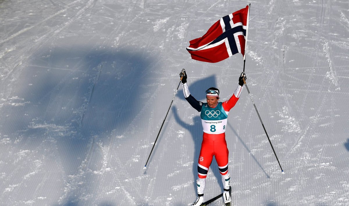 FILE PHOTO: Marit Bjoergen of Norway celebrates winning the race holding a Norway flag
