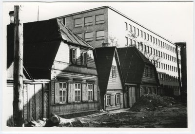 Jõe tänava viimased vanad puumajad 1960. aastatel. Omal ajal voolas nende majade eest Härjapea jõgi. Taamal Eesti Kaabli, tänane Pro Kapitali hoone.