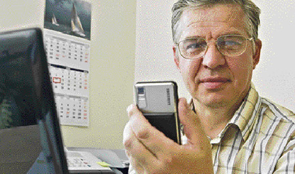 Kurtide liidu esimees Tiit Papp näitab abivahendeid, mille abil kurdid maailmaga suhtlevad — telefon sõnumite saatmiseks, arvuti ja faks.