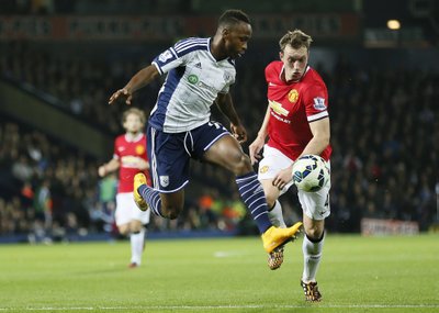 Saido Berahino of West Bromwich Albion and Phil Jones of Manchester United fight for the ball during their English Premier League soccer match at The Hawthorns in West Bromwich