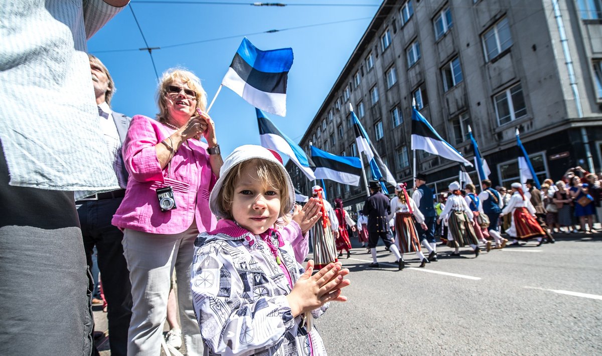 Foto on tehtud tänavusest laulupeo rongkäigust Narva maanteel, kus inimesed palistasid teeääri, lipud käes