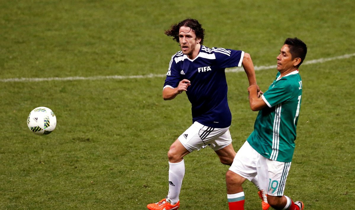 Puyol of Spain fights for the ball with Campos of Mexico during a friendly soccer match between FIFA Football Legends against Mexican all-stars at Azteca stadium in Mexico City