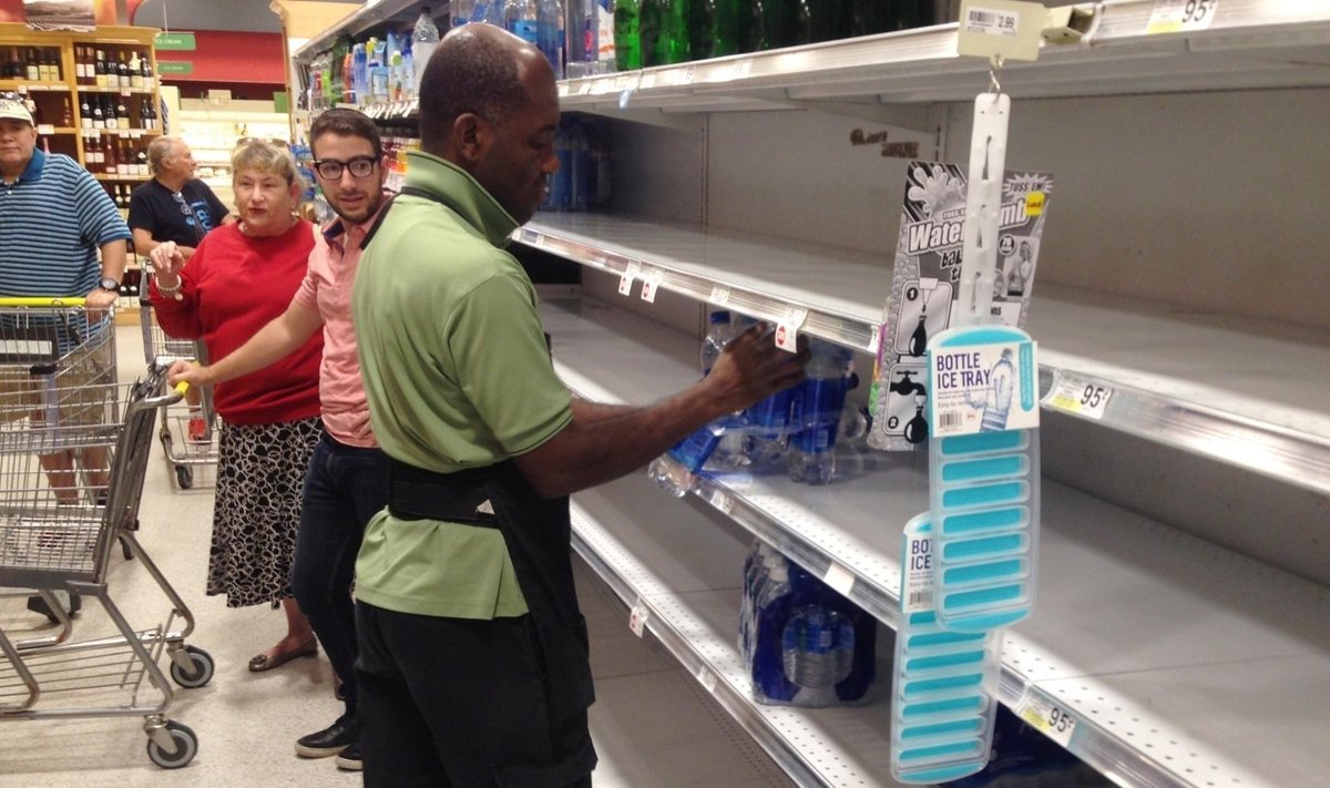 Люди закупают продукты, готовясь к урагану.