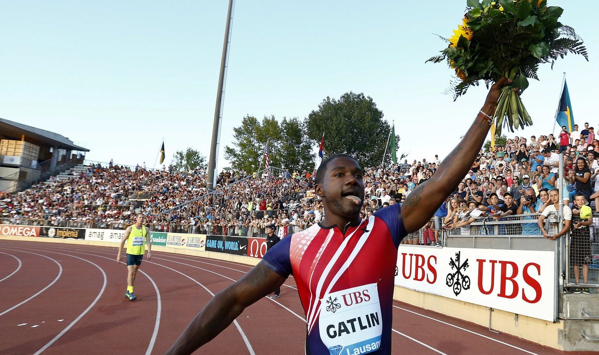 Justin Gatlin of the U.S. raises a bouquet of flowers after winning the men's 100m race during the Lausanne Diamond League meeting at the Stade de la Pontaise in Lausanne
