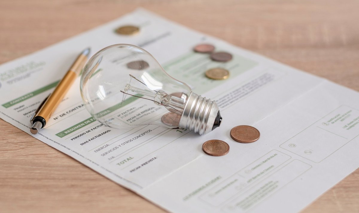 Electricity,Bill,With,Light,Bulb,,Several,Coins,And,Pen,On