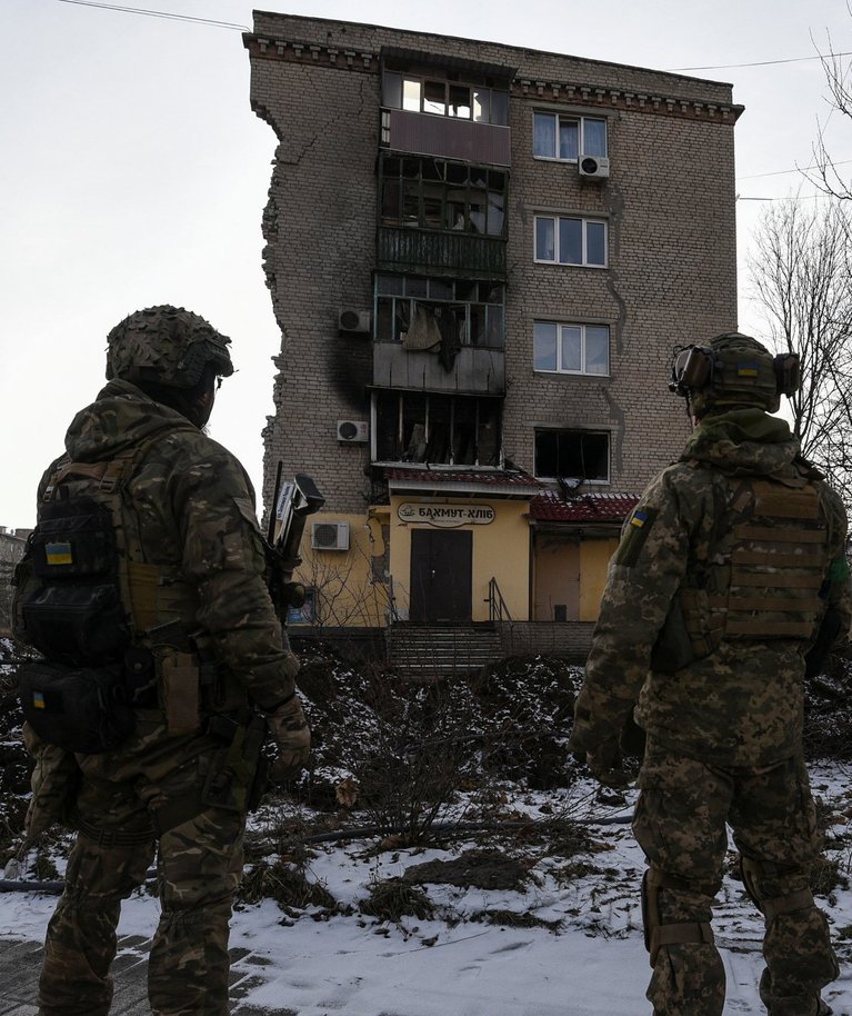 Ukraina sõjaväelased Bahmutis tugevalt kannatada saanud elamu kõrval. Foto tehtud 17. jaanuaril 2023.