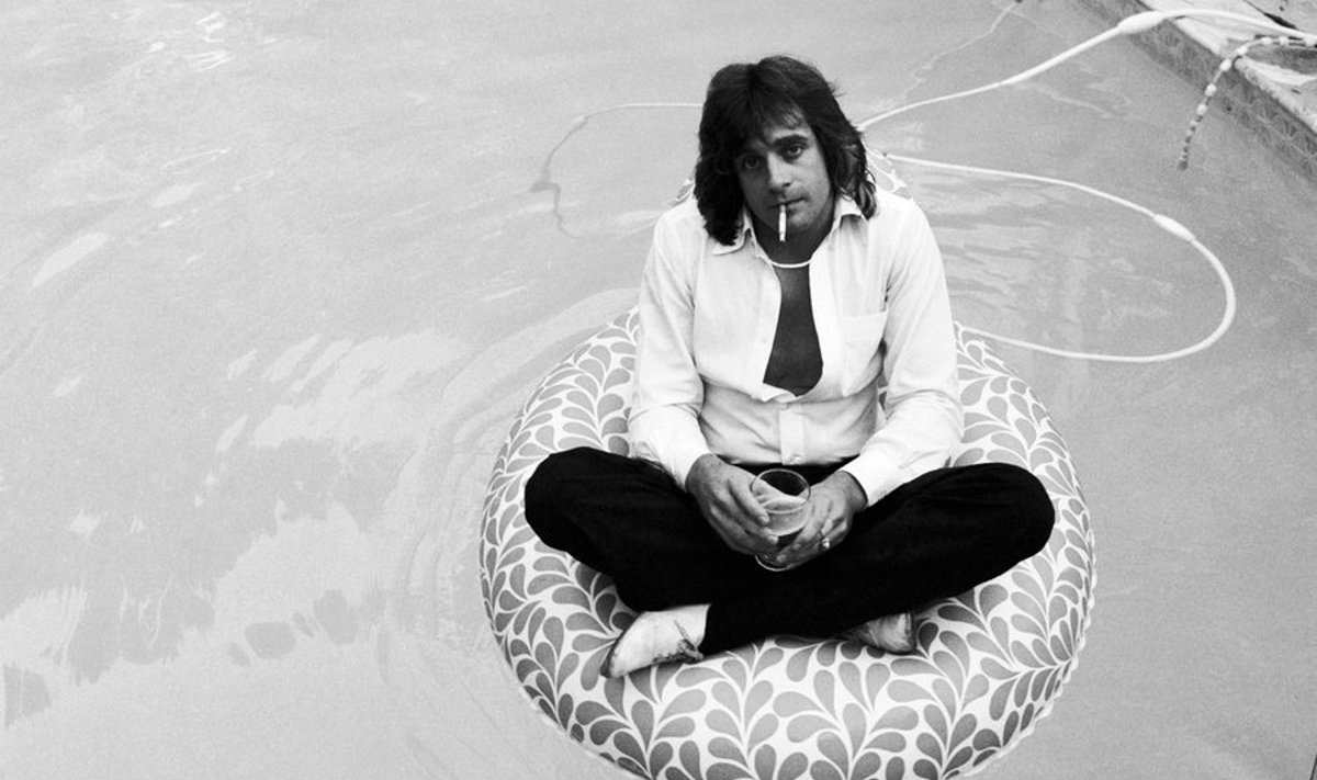26 May 1980, Lafayette, California, USA --- Eddie Money sits fully clothed on a rubber raft in his backyard pool. --- Image by 