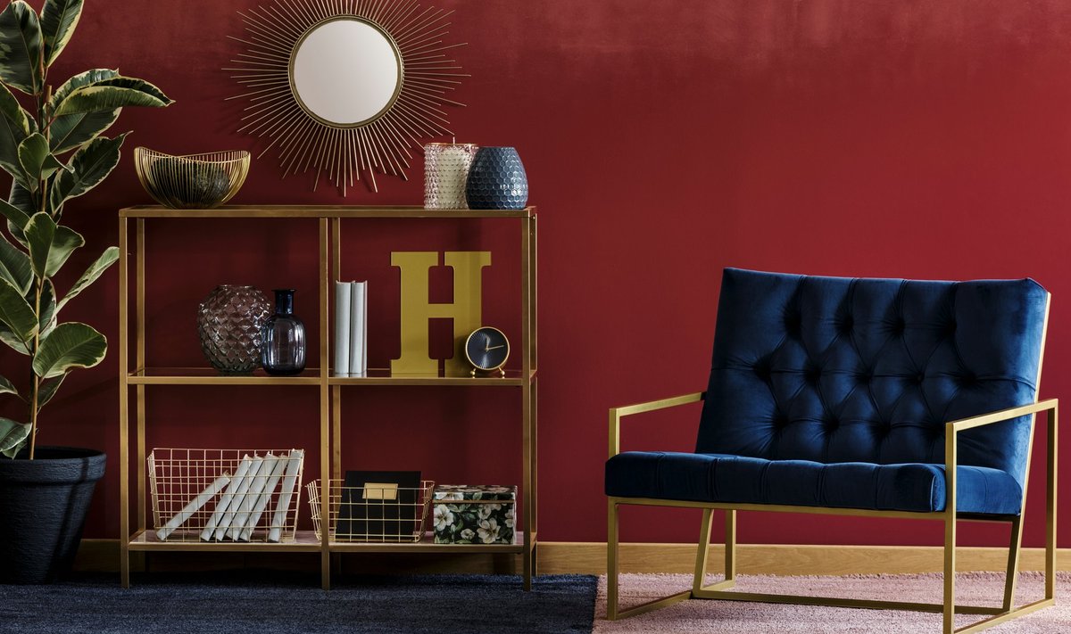 Golden,Metal,Rack,With,Books,And,Decor,Standing,In,Burgundy